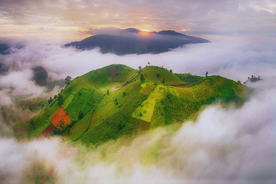 Mountain hilltop in Vietnam covered by clouds at sunrise on a scenic travel route